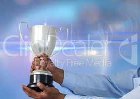 business hand with trophy, blue background whit flares