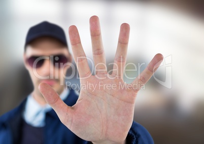 Security guard whit his hand up saying stop.