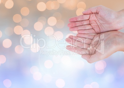 Hands open together with sparkling light bokeh background