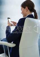 Seated business woman with phone against blurry blue wood panel