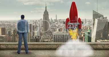 Digital composite image of businessman while launching rocket against cityscape