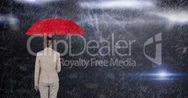 Digital composite image of businesswoman holding red umbrella while standing in rain