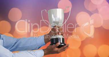 Hands holding trophy against defocused lights