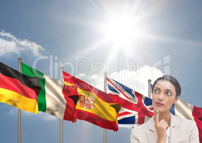 main language flags behind young businesswoman. Sky