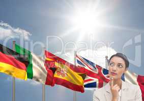 main language flags behind young businesswoman. Sky