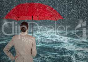 Back of business woman with umbrella against stormy sea with rain