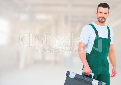 Construction Worker with tool box in front of construction site