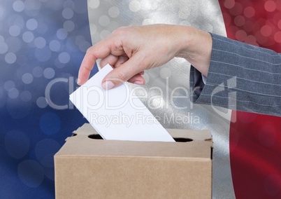 Hand putting France vote in ballot box with sparkling light bokeh background
