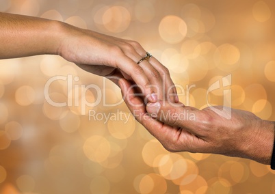 Two Hands holding eachother with sparkling light bokeh background