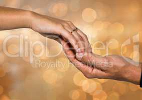Two Hands holding eachother with sparkling light bokeh background