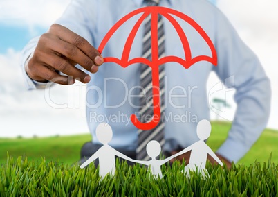 Cut out umbrella protecting family on grass