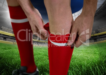 soccer player in the field putting well his red shocks