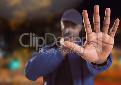 man with stop hand gesture on city street at night