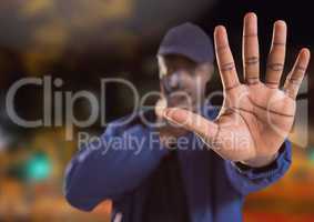 man with stop hand gesture on city street at night