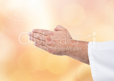 Hands together praying meditating with sparkling light bokeh background