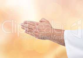 Hands together praying meditating with sparkling light bokeh background