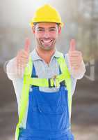 Construction Worker giving thumbs up in front of construction site
