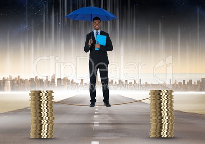 Digital composite image of businessman holding blue umbrella balancing on rope amidst stack of coins