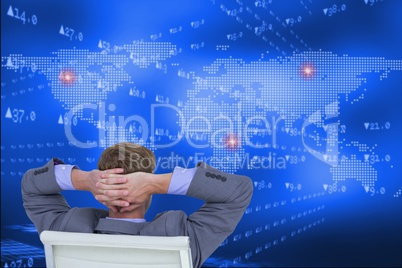 Businessman seated in chair watching digital background