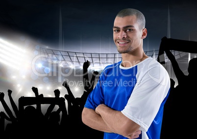 happy soccer player with blue t-shirt, in front of the fans and the field