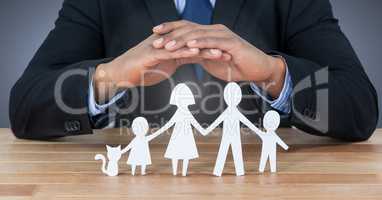 Cut out family under protective hands