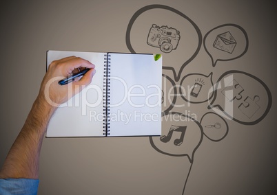 Overhead of hand writing with notebook and speech bubble doodle against brown background