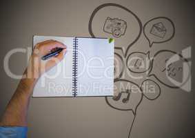 Overhead of hand writing with notebook and speech bubble doodle against brown background