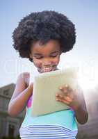 Kid with tablet against sky and building with flare