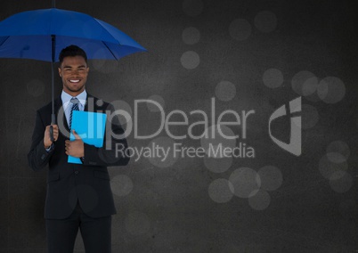 Business man with umbrella and blue book against grey wall and bokeh