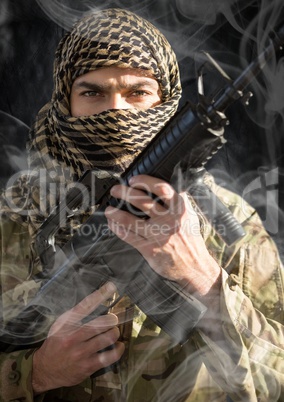 soldier with face covered and weapon in his hands, looking us. smoke around him. black background