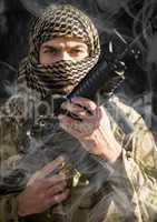 soldier with face covered and weapon in his hands, looking us. smoke around him. black background