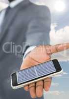 solar panel on the phone of the businessman hand. sky background