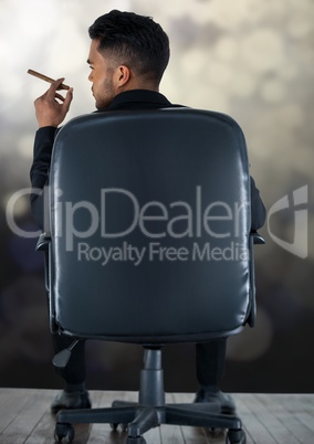 Businessman Back Sitting in Chair with cigar and bokeh sparkling lights