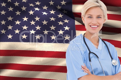 Smiling doctor with arm crossed against american flag