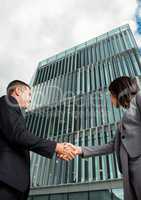 business man and woman handshake in front of the building