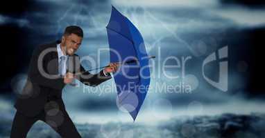 Business man with umbrella blocking wind against stormy sky and bokeh