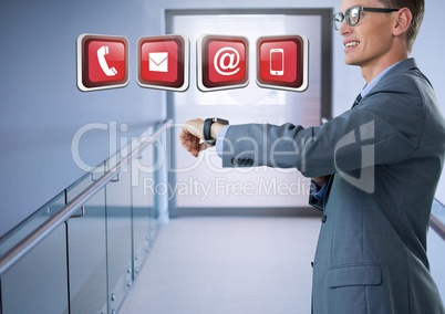 Businessman holding smart watch with apps in corridor