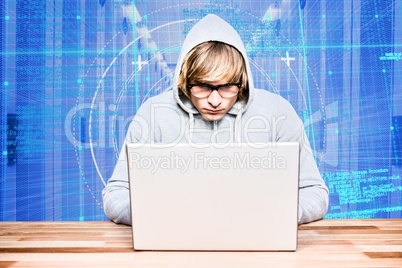 Hacker using a laptop with a blue digital background