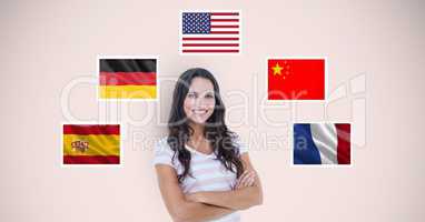 Portrait of beautiful woman with arms crossed standing by flags against beige background