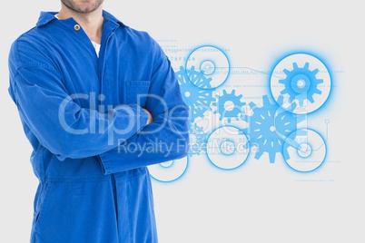 Mechanic with arms crossed in front of cogs