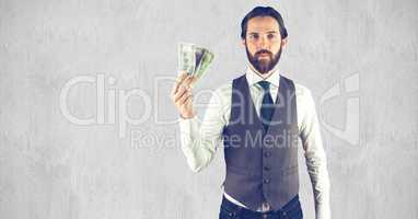 Creative businessman holding currencies while standing against wall