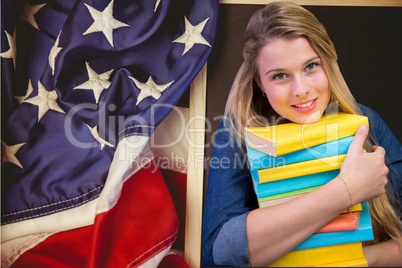 students holding books against american flag background