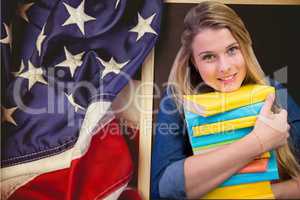students holding books against american flag background