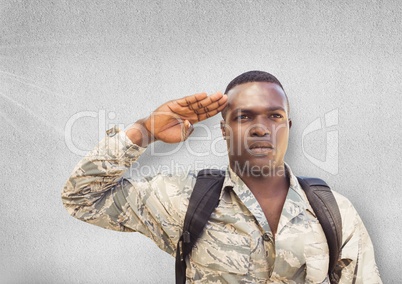 serious soldier saluting. Concrete wall