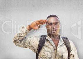 serious soldier saluting. Concrete wall