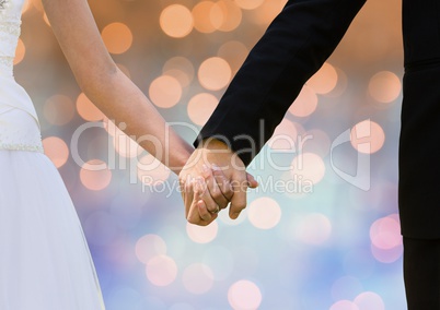 Couple Hands holding wedding couple with sparkling light bokeh background