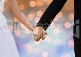 Couple Hands holding wedding couple with sparkling light bokeh background