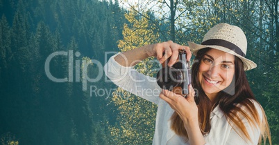 Happy casual woman taking a picture in front of wood background