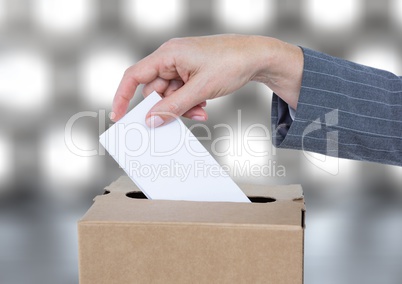 Hand putting vote in ballot box with sparkling light bokeh background