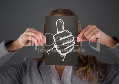 Business woman with black card over face showing white thumbs up doodle against grey background